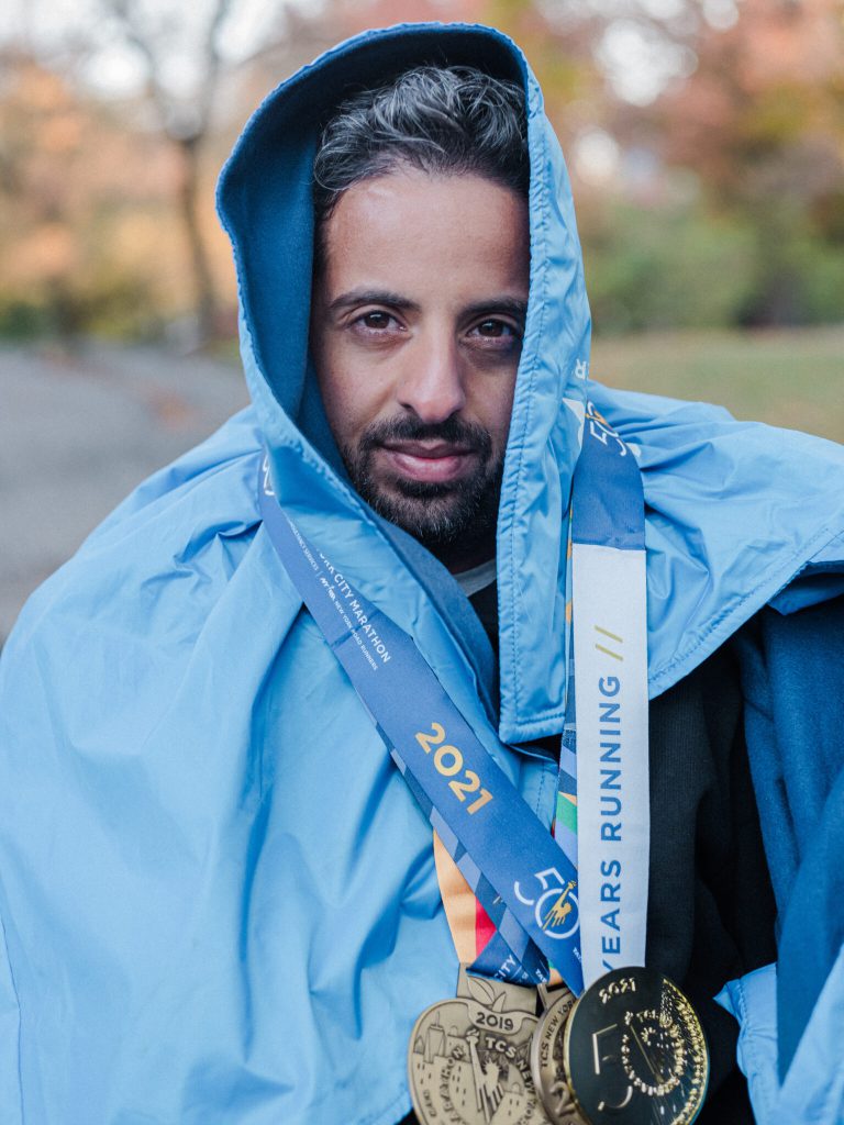Bishoy Life Coach host of Mile 40 Running Podcast wearing medals